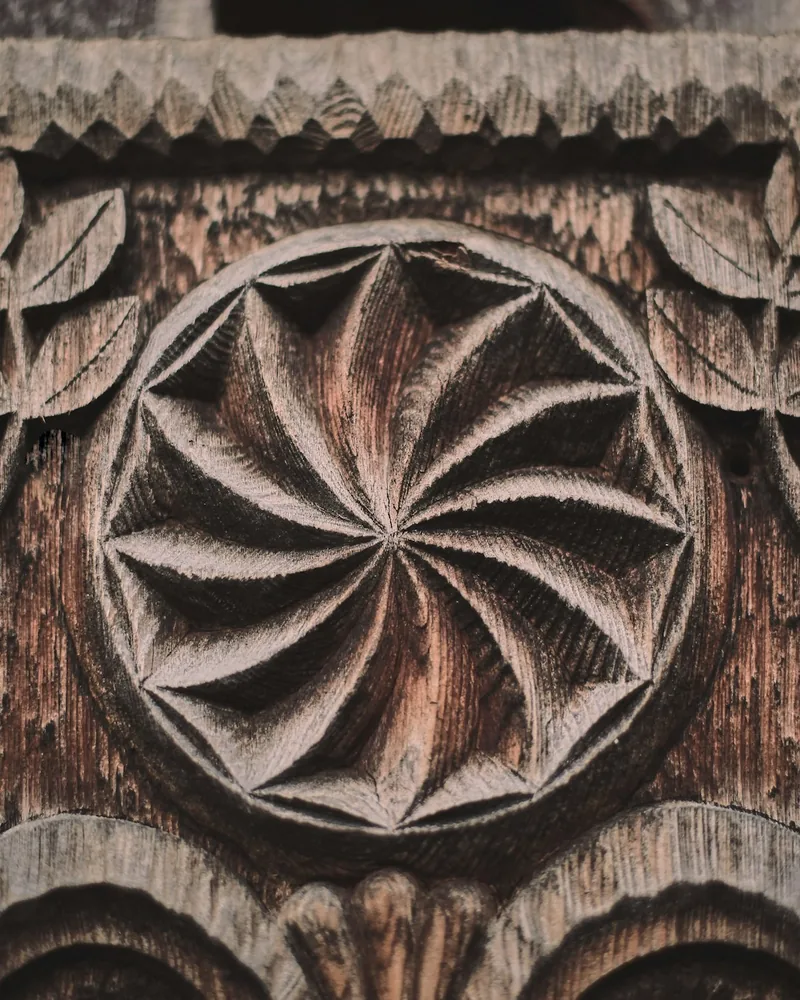 Detalle de un panel de madera con ornamento tallado en relieve y fondo rebajado